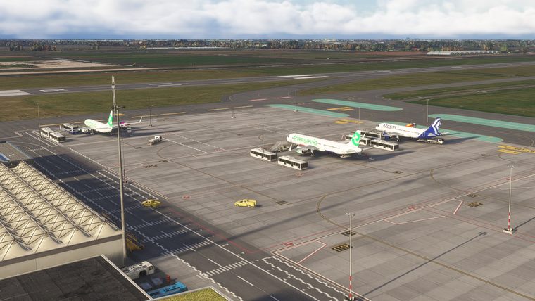 Rotterdam's apron from above, two Transavia aircraft and an Aegean airliner on stand with buses and stairs beside them.